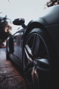 Close-up shot of a sleek, modern luxury sports car wheel with focus on design and details.